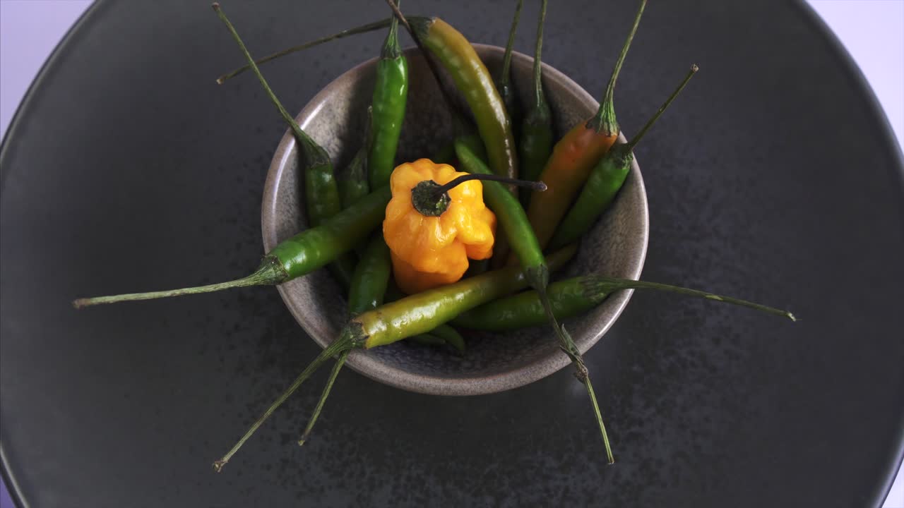 파란색 배경의 중간에 신선한 캐롤라이나 사신과 함께 회전하는 칠리 페퍼의 상위 뷰