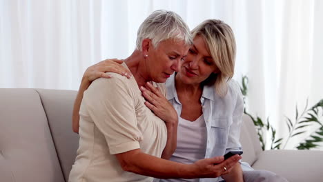 Mujer-Leyendo-Malas-Noticias-Desde-Su-Teléfono-Y-Su-Amiga-La-Está-Consolando.