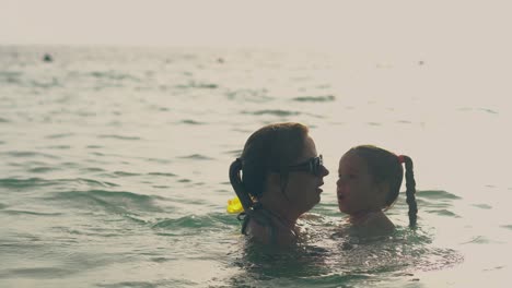 Silhouetten-Von-Mutter-Und-Tochter,-Die-Im-Meerwasser-Schwimmen