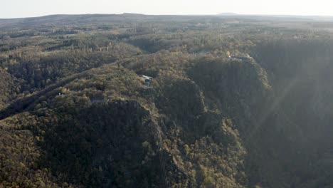 Drone-Aerial-view-of-Thale,-the-Rosstrappen,-Hexenstieg,-Hexentanzplatz-and-the-Bodetal-in-the-north-of-the-Harz-national-Park-in-late-autumn-at-sunset,-Germany,-Europe