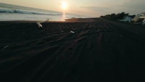 low aerial on volcanic sandy beach of playa de monterrico in guatemala