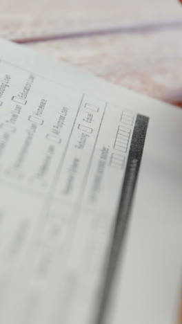 close-up of businessman sitting at desk filling contract