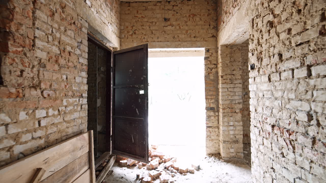 Inside the building under construction. Bare brick walls in the hall and materials for interior design.