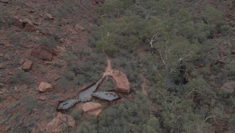 viewing platform at kings canyon rim walk with female tourist standing. watarrka national park, northern territory, australia. drone descend