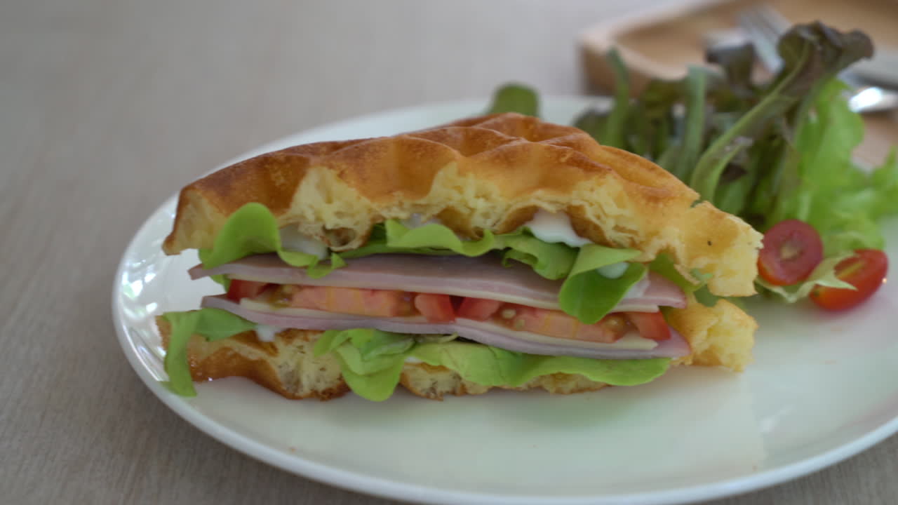 sándwich de jamón con queso y gofres en un plato