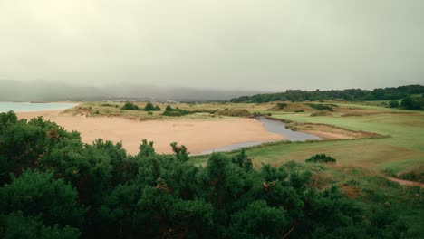 tee box view of sandy coastline of portsalon beach on ireland links golf course