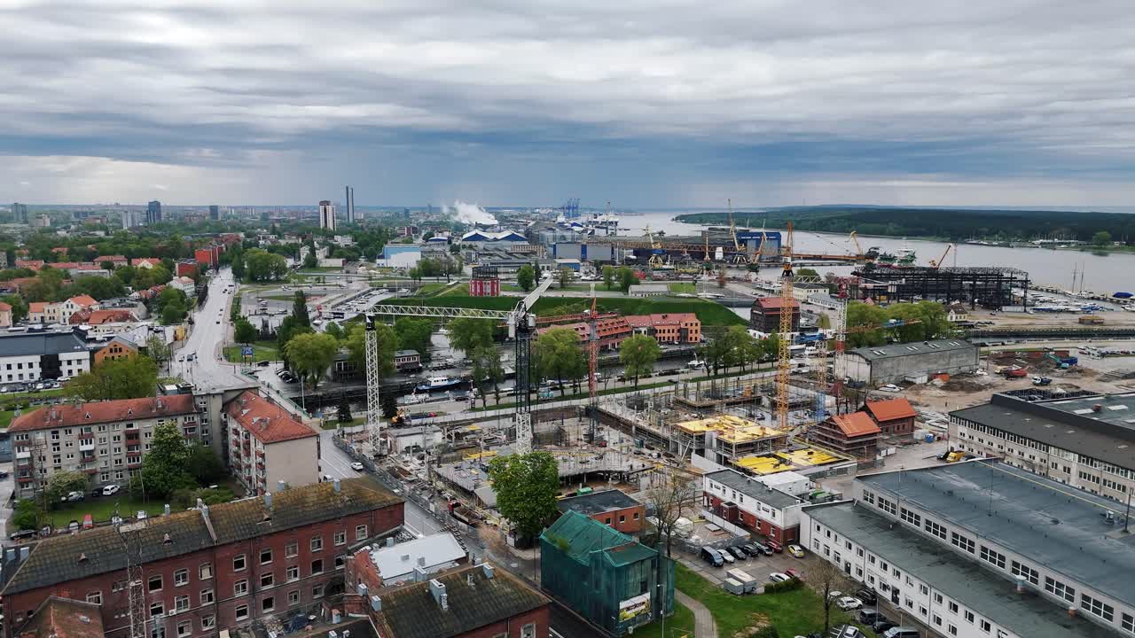 발트해 연안의 클라이페다 주에서 구름이 가득한 하늘 아래의 새로운 건설 개발 현장의 드론 촬영