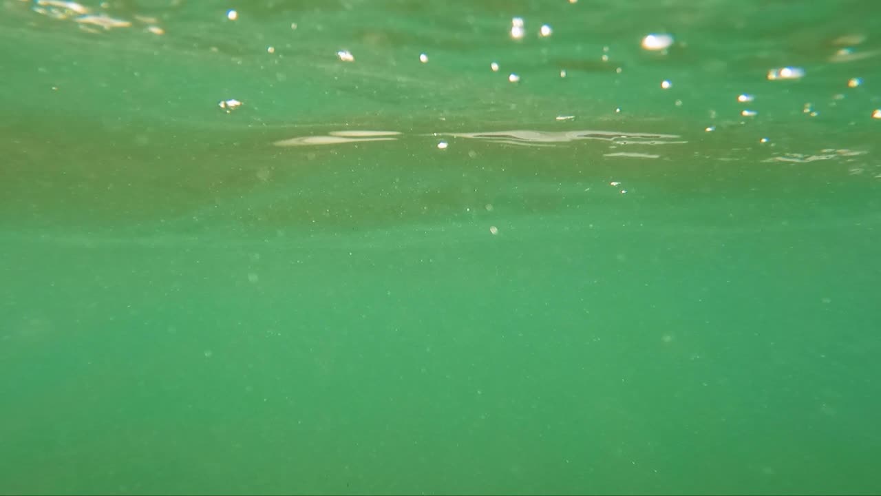 그린초 서프 스 ⁇ 의 끝에 절벽이 있는 초록색 바다 또는 물에 있는 공기 거품