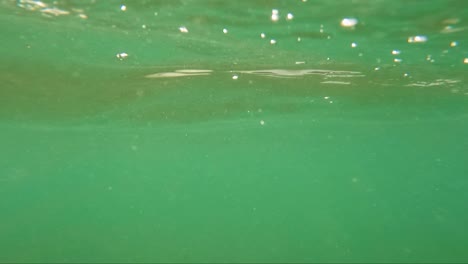 burbujas de aire en el mar verde o agua con acantilados en el extremo en el lugar de surf de guincho