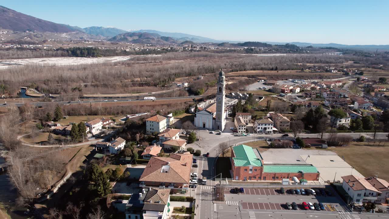 마을과 언덕 환경에서 교회의 궤도 하강으로 공중 전방 보기