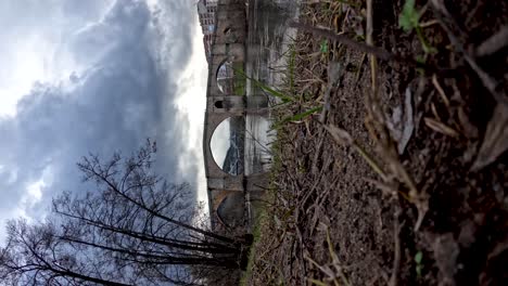 Vertical-timelapse-of-ancient-historic-roman-bridge-over-river-in-ourense,-spain