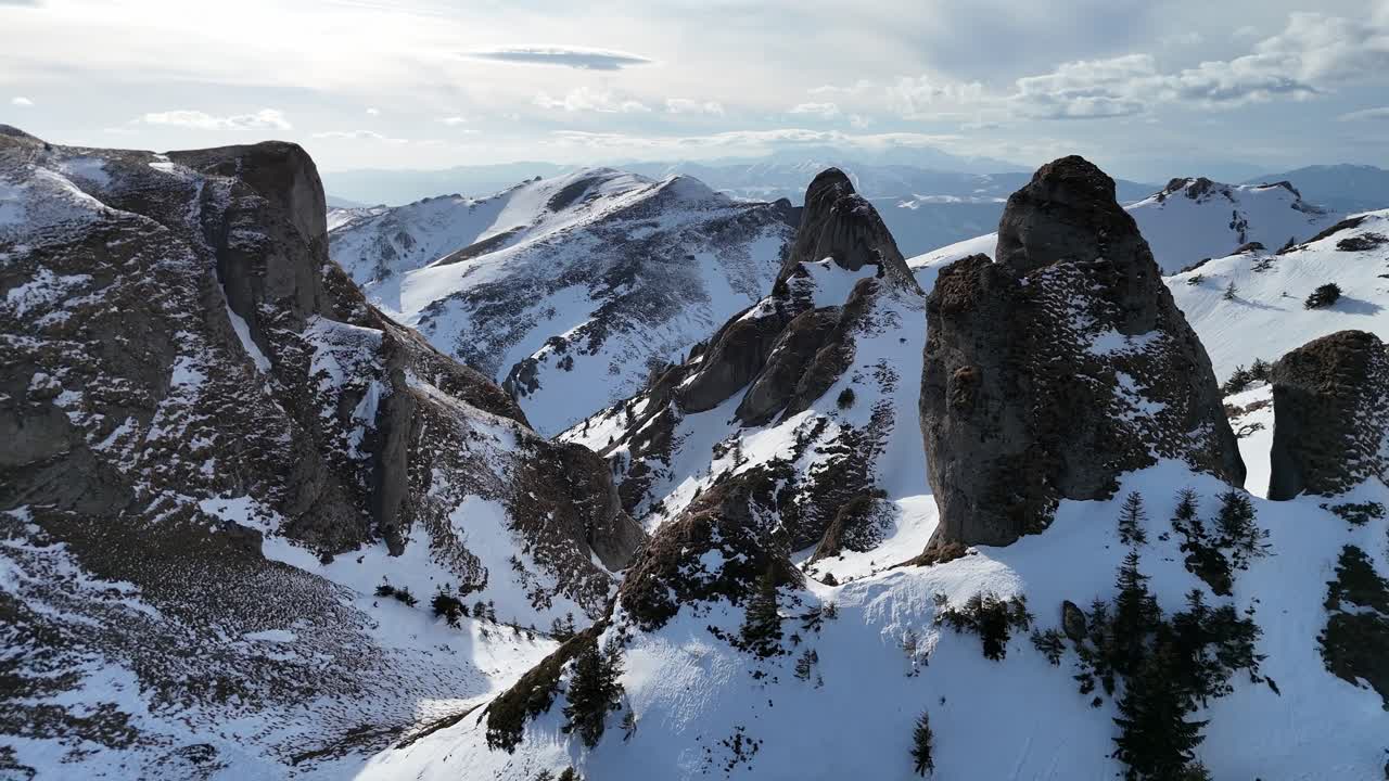 fotografía aérea de las montañas ciucas en invierno con picos cubiertos de nieve bajo un cielo despejado