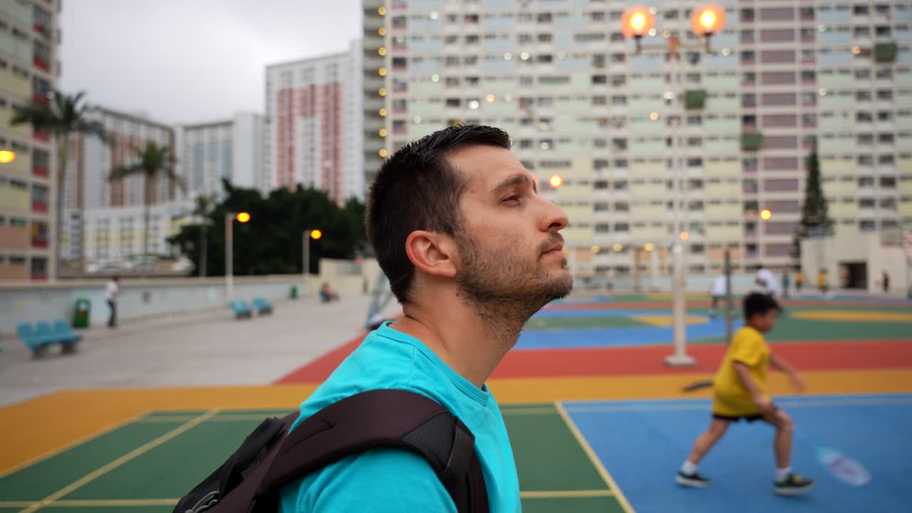 Tourist man amazed by local kids playing badminton in Choi Hung Estate, Hong Kong