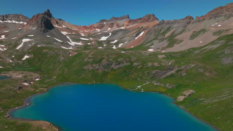 dreamy heavenly silverton ice lake basin aerial drone cinematic unreal deep sky blue stunning by island lake silverton colorado lush green summer incredible snow melting rocky mountains backward