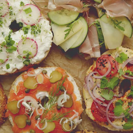 circular bread bagel sandwich served with various toppings  samlon  ham and cheese  cottage  hummus