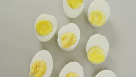 video of overhead view of halves of hard boiled eggs on grey background