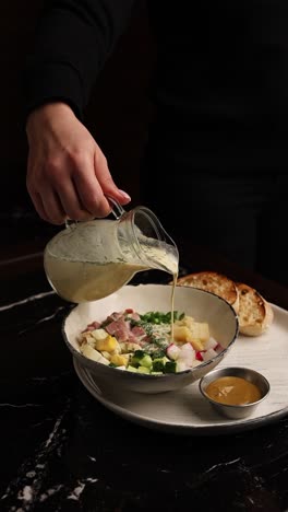 woman pouring cream soup into bowl