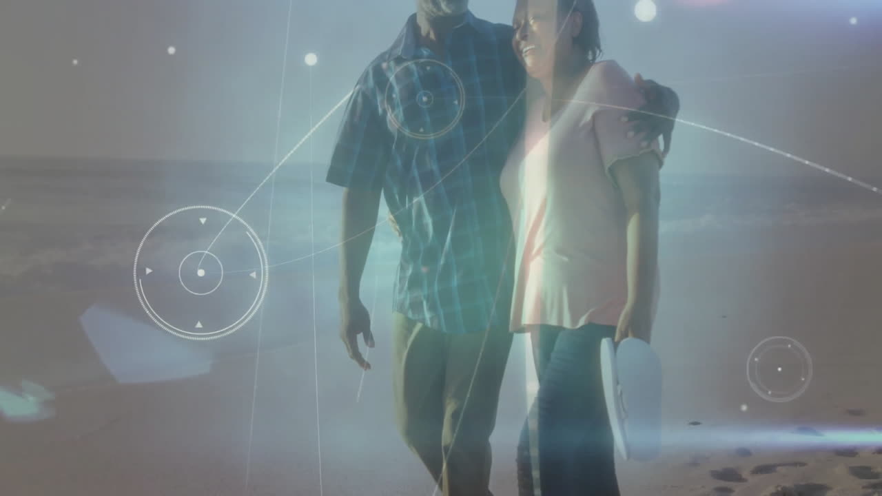 Smiling couple walking on beach with digital network animation overlay