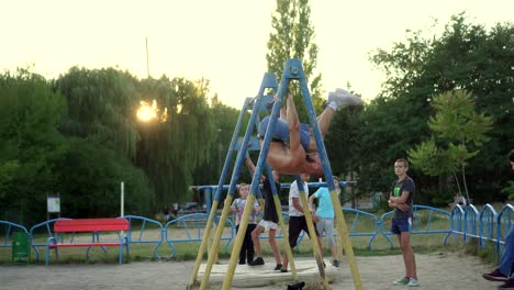 a man plays sports on a horizontal bar in the park