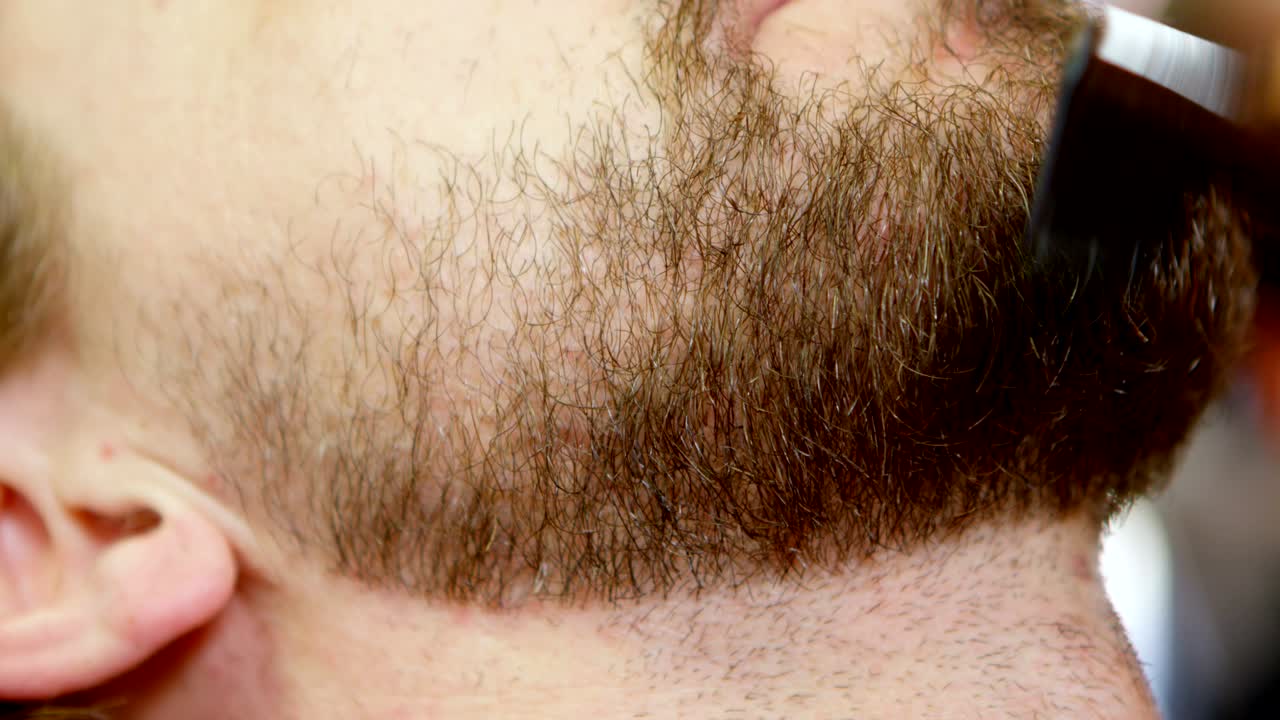 hombre recortando su bigote con tijera 4k