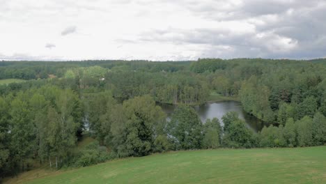 green trees surrounding the lake in piaszno village seen from the mountain hills on a bright day in pomeranian voivodeship, northern poland