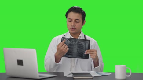 Sad-Indian-doctor-explaining-X-ray-report-to-the-camera-Green-screen