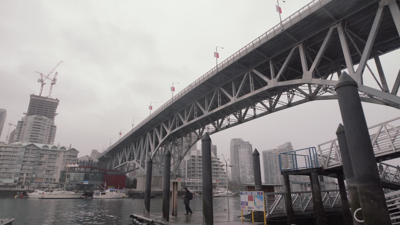 흐린 날 그랜빌 아일랜드 다리 아래에서 페리를 기다리는 남자