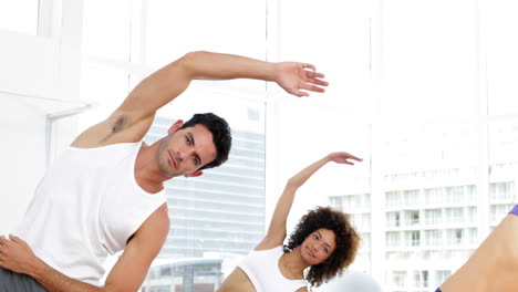 Fitness-class-stretching-their-arms-together