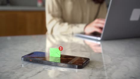 receiving text message on mobile smart phone, animated envelope icon with woman working on her laptop at background