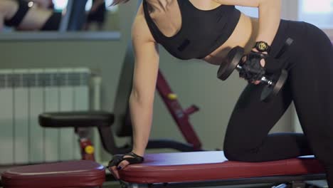 woman working out with dumbbells in gym