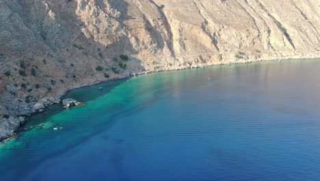 vue de drone en grèce faisant le tour d'une colline brune sur une montagne à côté de la mer bleue de la méditerranée par une journée ensoleillée