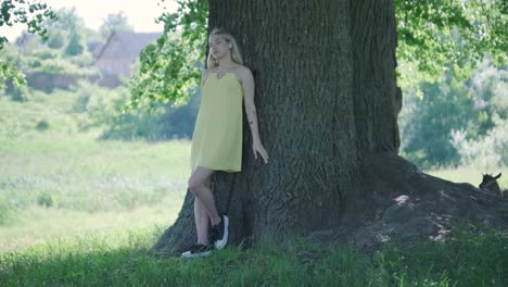 happy beautiful young girl dancing of freedom in summer park with trees in the background.