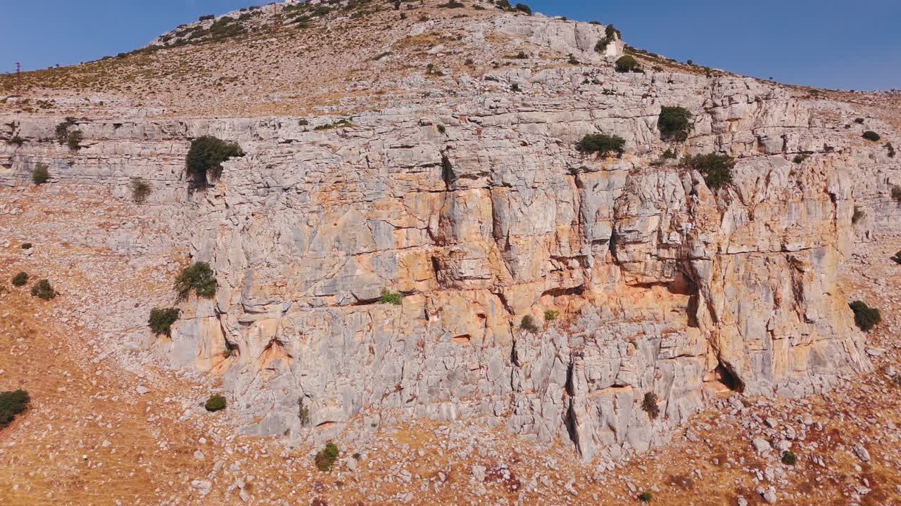 Vista ravvicinata di una parete rocciosa aspra e di un pendio roccioso.