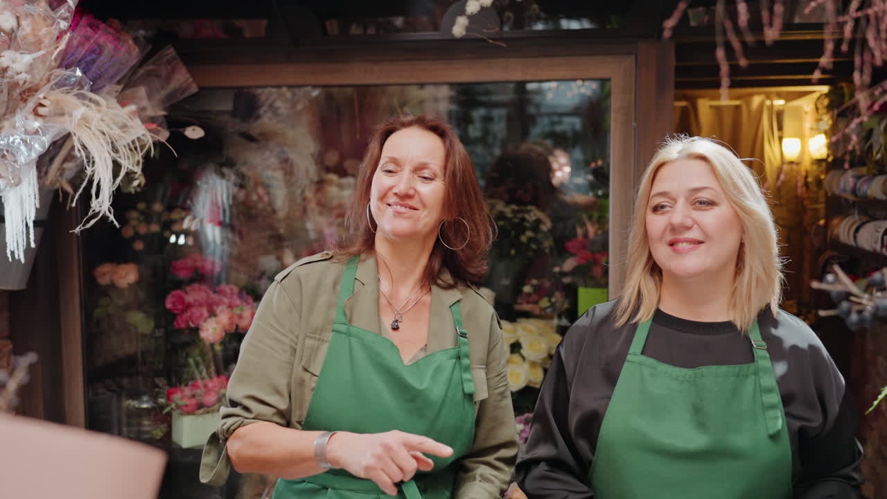 Kunde überreicht Blumenstrauß an Floristen, Inhaber und Verkaufsassistent empfangen Geschenk mit herzlichem Lächeln und sanften Händen, Pfingstrosen- und Rosenblüten umrahmt von rustikaler Ladenfront und gemütlichen Blumenauslagen