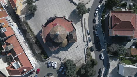 behold the awe-inspiring aerial view of a charming red-roofed chapel nestled amidst lisbon's vibrant and colourful urban landscape, a stunning fusion of european architecture