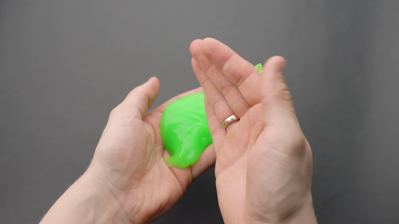 Green slippery slime in person hands, POV view