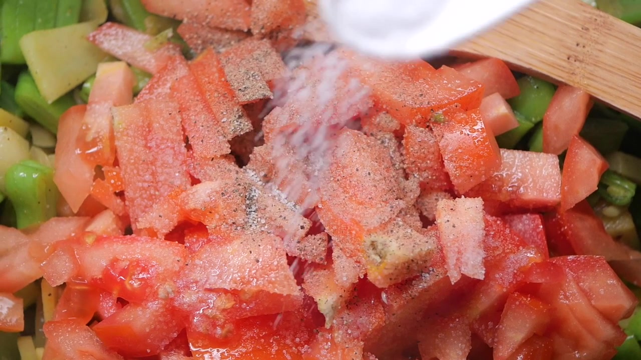 Sprinkling Salt and Pepper on Chopped Tomatoes and Vegetables