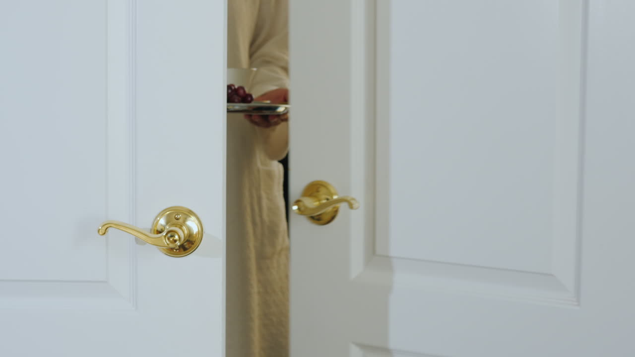 목욕 가운을 입은 한 여성이 로맨틱한 아침을 객실로 가져옵니다.