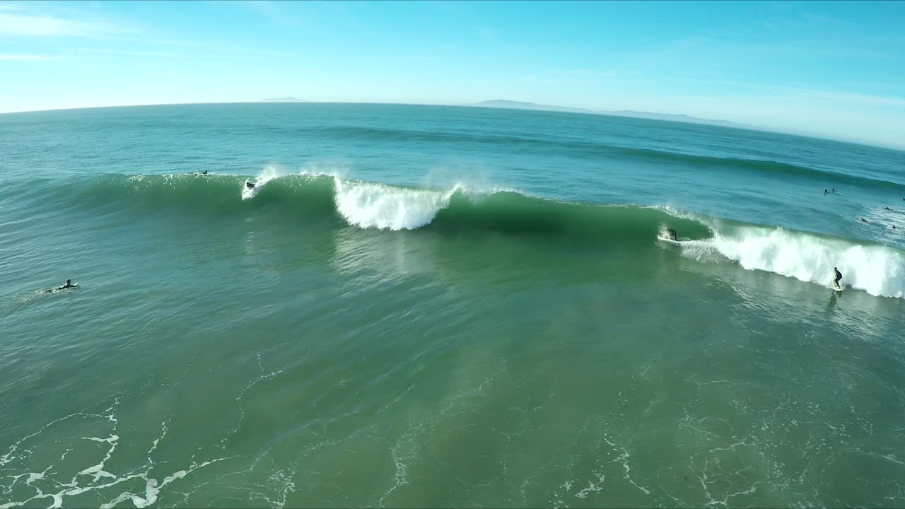 antena sobre surfistas montando olas en una playa del sur de california 2