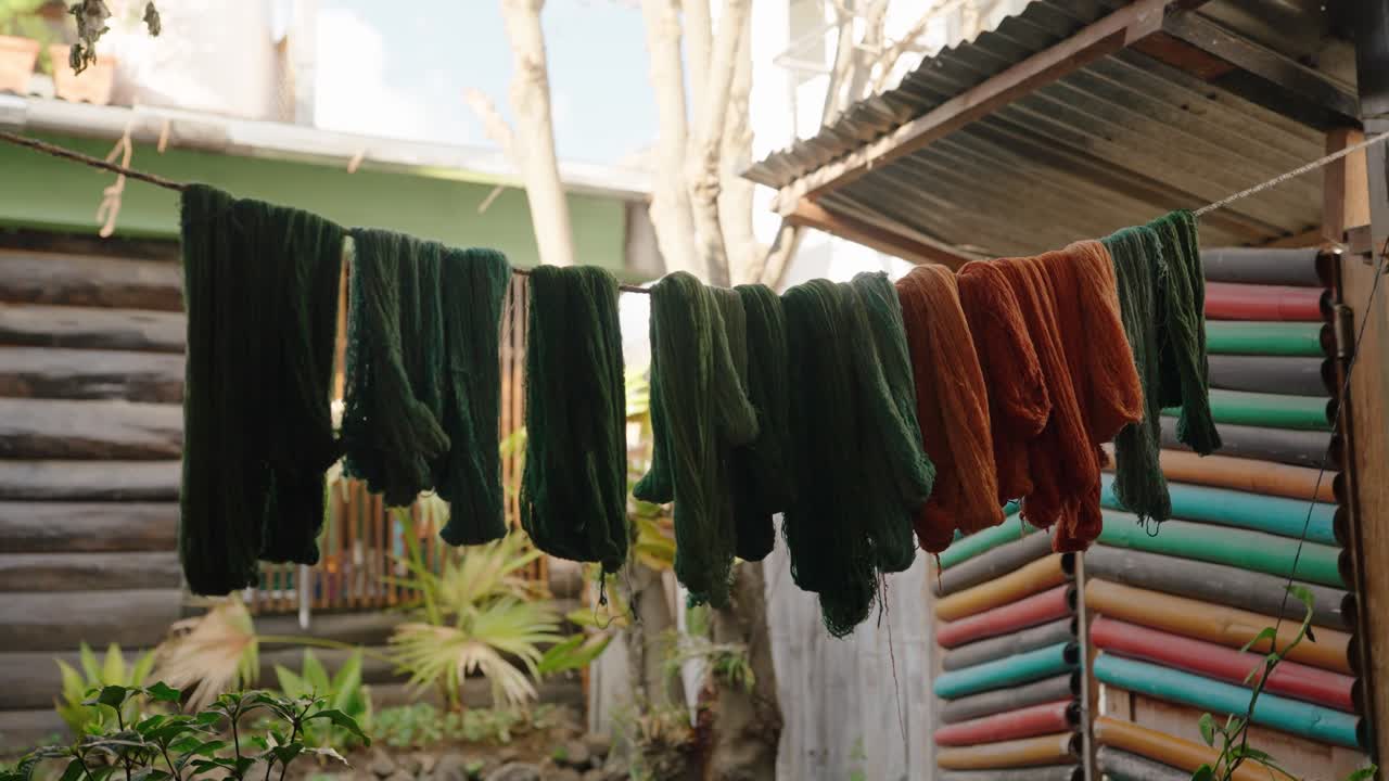 Filato tinto naturalmente appeso ad asciugare in un laboratorio di tessitura guatemalteco
