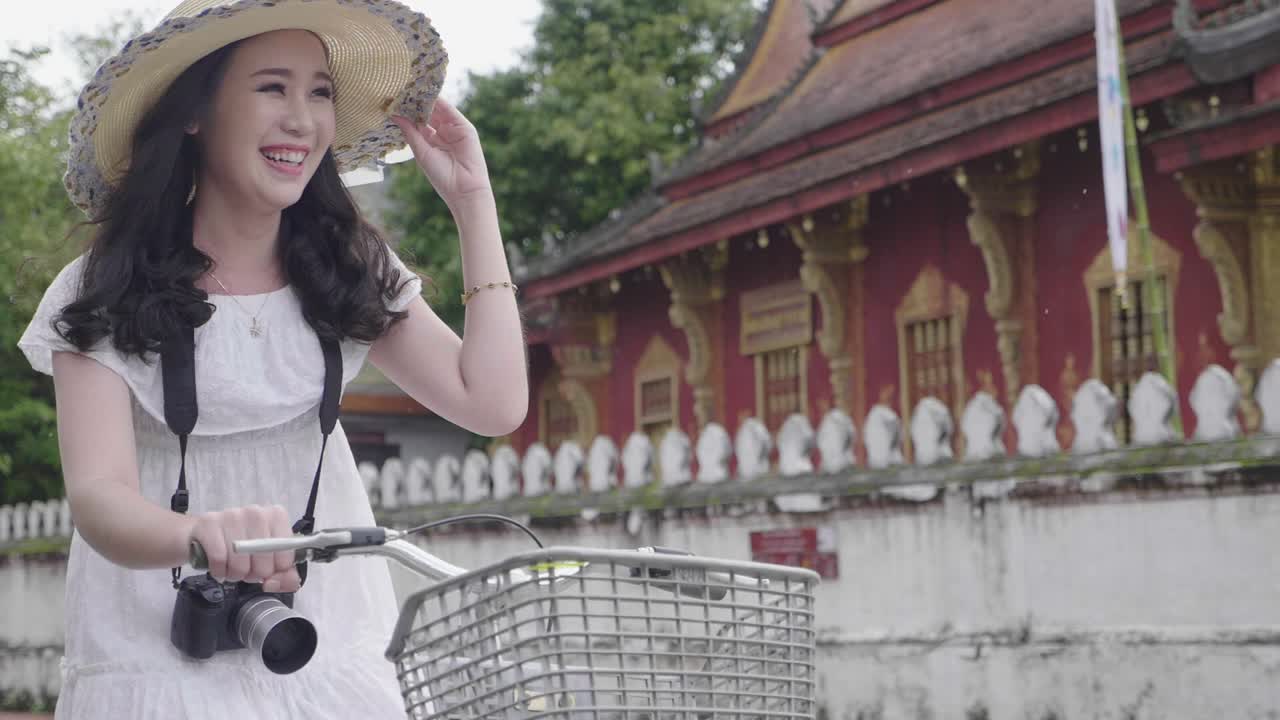 Beautiful Tourist Cycling To Visit Luang Prabang In The Rain, Slow Motion
