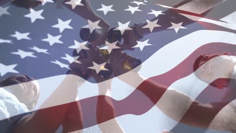 Group-of-friends-toasting-bottles-and-the-American-flag-for-fourth-of-July