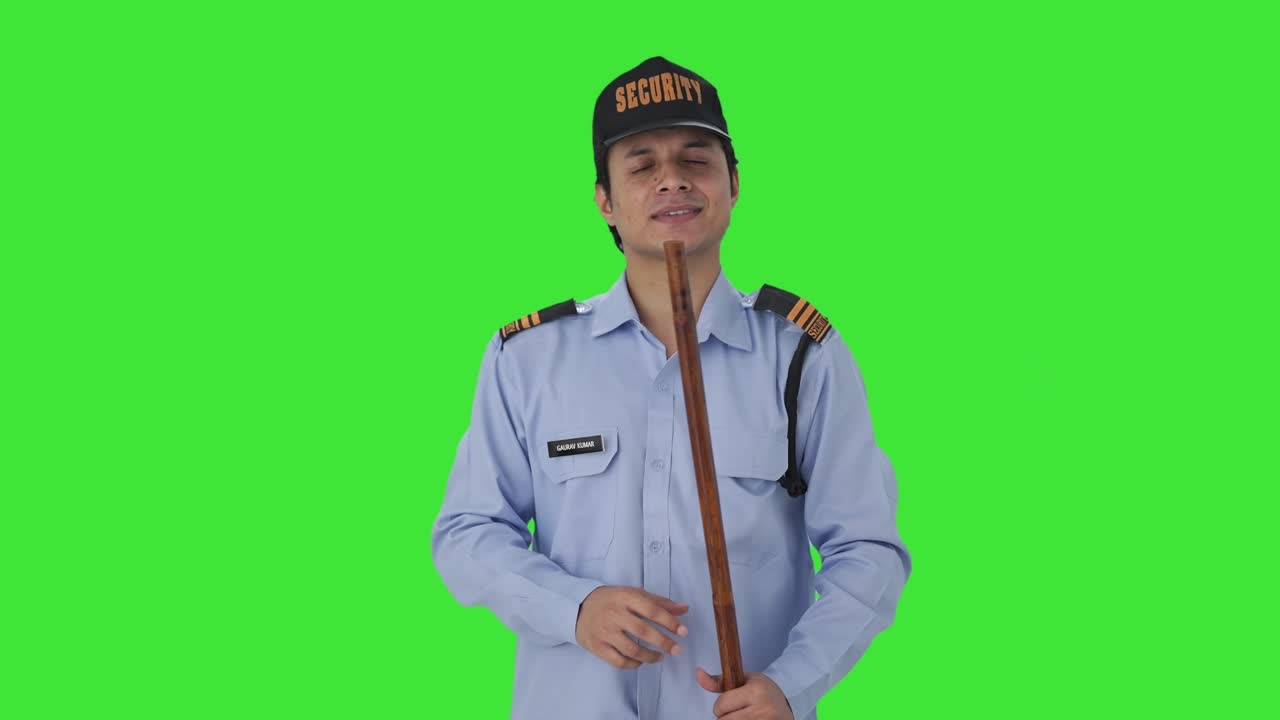 Guardia di sicurezza indiana felice che ascolta qualcuno, su schermo verde.