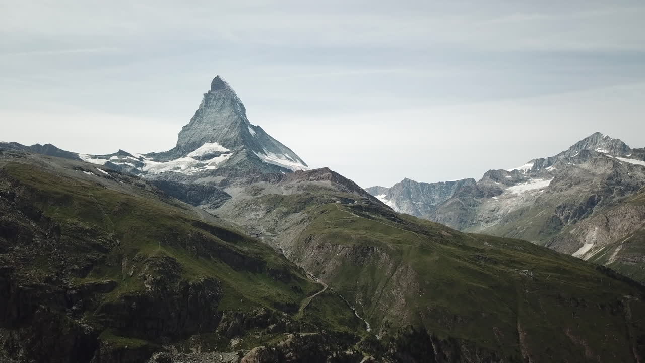 cumbre cubierta de hierba de los alpes suizos: vista sobre el cervin con sus rocas afiladas y su nieve, pico de montaña de gran altitud, vista aérea de drones, naturaleza