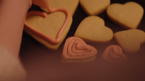 decorating heart-shaped cookies with pink icing
