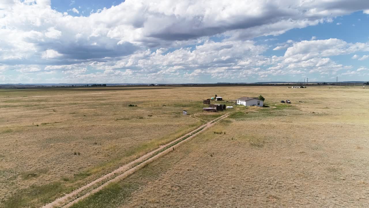 A dropping altitude shot of a small farm house on the Great Plains of North America