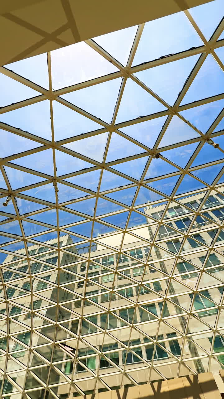 Geometric ceiling in modern design. Bright blue sky through a geometric glass ceiling in a modern building, highlighting urban design