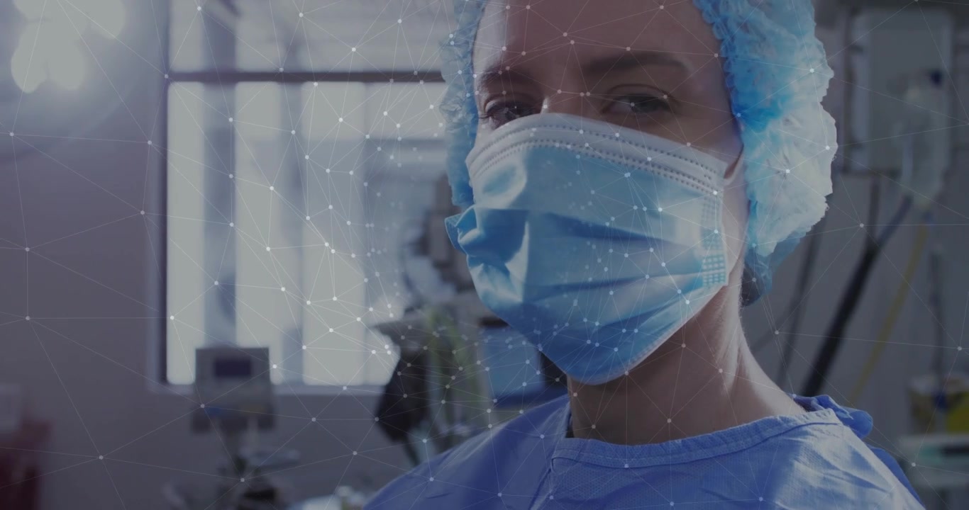 Clinica che si prepara per una procedura, sollevando e fissando una maschera blu mentre appaiono delle particelle.