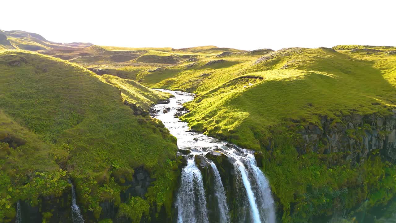la parte superior de una cascada de skógafoss en islandia, el agua fluye sobre una exuberante meseta verde de la naturaleza