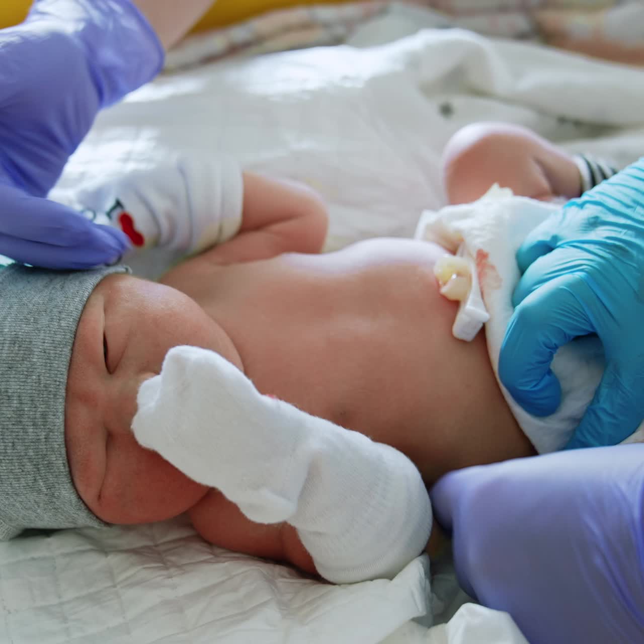 Adorable newborn child in the maternity hospital. Pediatrician listens to the heartbeat of an infant. Nurses take care of a baby